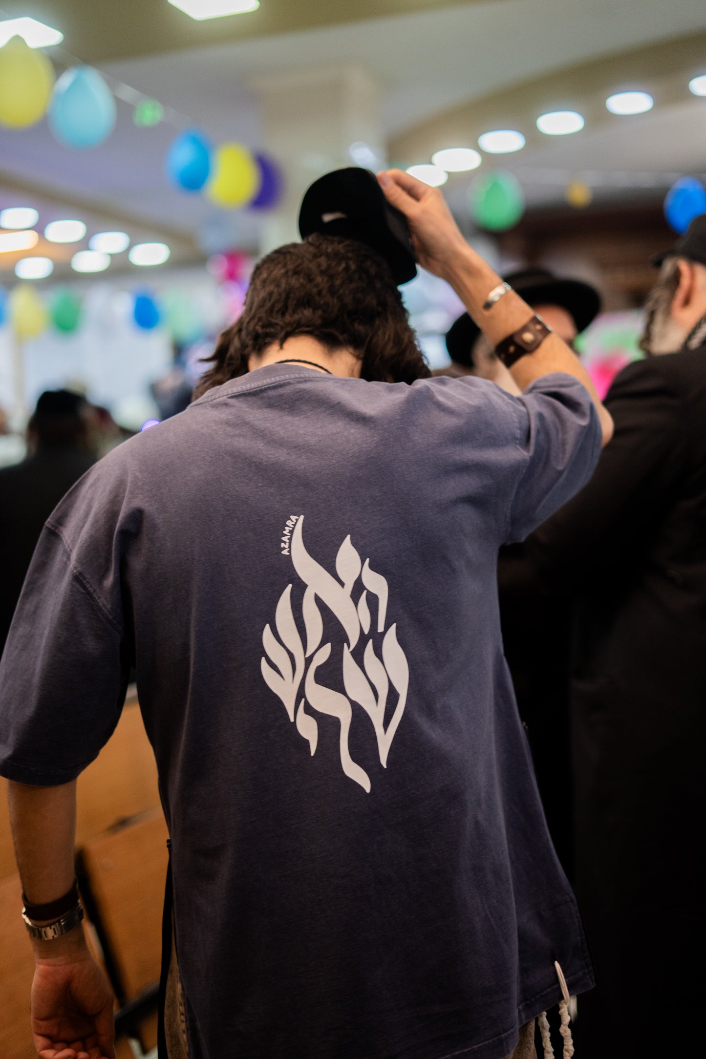 Homme de dos portant le t-shirt Tsitsit casher Aesh Sheli bleu délavé de la marque Azamra, vêtement halakhique streetwear inspiré de Rabbi Nahman
