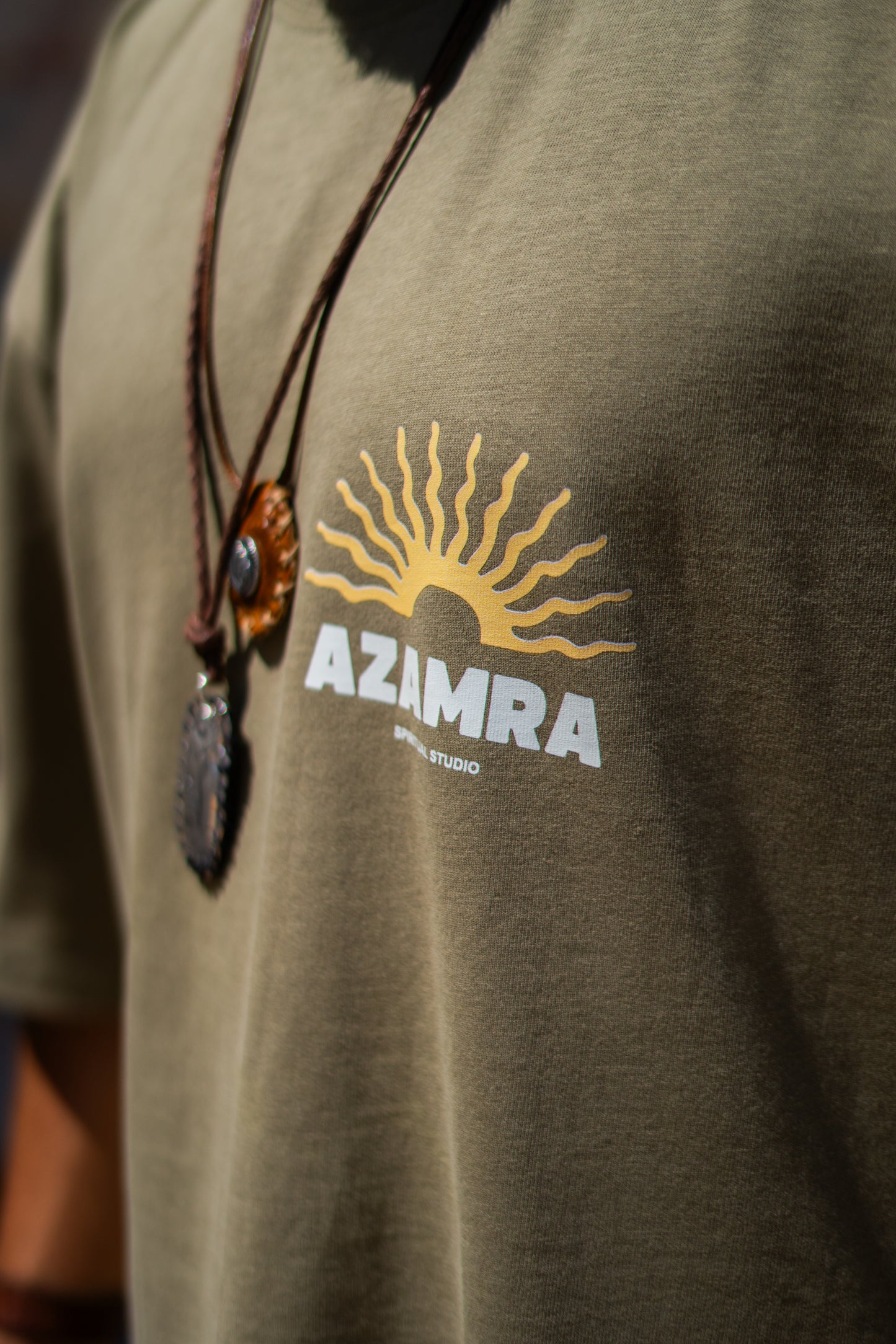 Zoom sur la matière coton kaki et le logo azamra boheme avec colliers breslev et petek