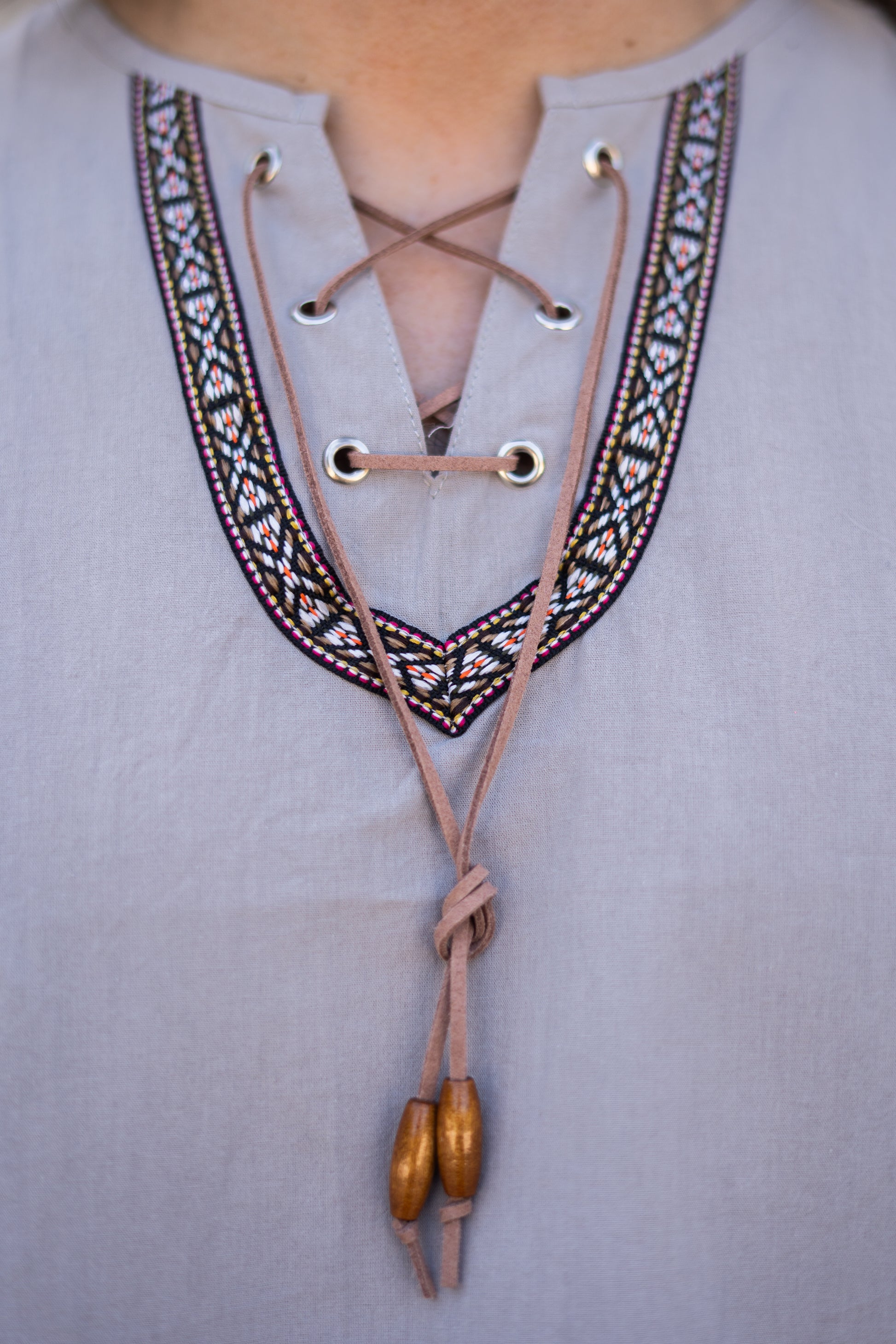 Détail du col brodé boho avec cordon ton sur ton et perles